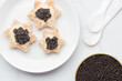Black caviar appetizers bread star on a white background top view