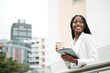© Mia B/peopleimages.com - Black woman, coffee break and corporate employee with tablet outside the office, working in a city and career marketer. Digital technology, African American professional and a businesswoman outdoors
