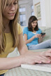 © Designpics - Teenage girls using technology, one on a laptop and one on a smart phone