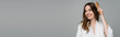 © LIGHTFIELD STUDIOS - cheerful young woman brushing shiny and healthy hair while looking away isolated on grey, banner