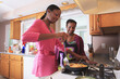 © Designpics - Two sisters cooking in the kitchen, one with learning disability