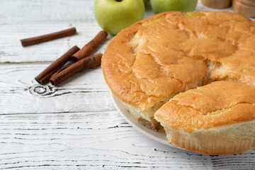 apple pie charlotte on white wooden table with fresh apple and cinnamon