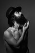 © Cavan Images - Portrait of a man with beard and hat naked. Shirtless. black and white