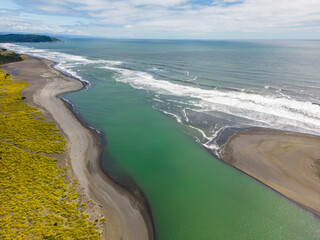 Aerial shot of the point where the river Tolten flows into the pacific ocean in Araucania, Chile 