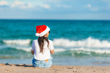 Wall Mural - Young woman in Santa hat on Christmas beach holidays