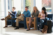 © Designpics - Passengers seated in an airport lounge all using electronics