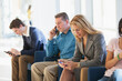 © Designpics - Passengers seated in an airport lounge all using electronics