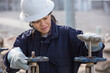 © Designpics - Female power engineer adjusting water valves at power plant