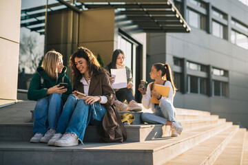 Wall Mural - College friends are sitting on the stairs in front of the college building on a sunny day