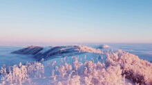 Aerial View Of A Snow-covered Mountain And The Inversion Illuminated By Sunrise Rays That Color The Clouds Orange-pink. Breathtaking Morning On Skalka Mountain, Beskydy Mountains, Czech Republic