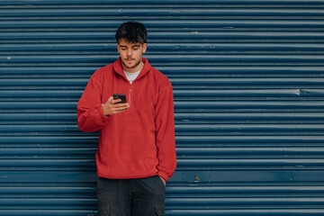 Poster - young man with mobile phone in the street with copy-space