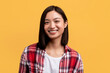 Happy person. Portrait of young asian lady with beautiful smile, looking at camera, posing in studio, yellow background
