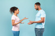 © Prostock-studio - Communication. Profile portrait of black woman and man talking and gesturing over blue studio background