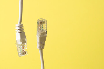 Network connection, internet connection and computer technology concept, close-up of ethernet cable connector, on yellow background