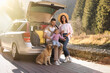 © New Africa - Parents, their daughter and dog near car outdoors. Family traveling with pet