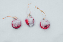 Concept Of The Postcard With Christmas Baubles Covered With Snow, Three Red Baubles