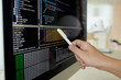 © DragonImages - Hand with pen pointing at screen with programming code