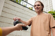 © DragonImages - Smiling young man swiping credit card when paying for pizza delivery