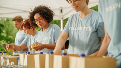 Portrait of a Black Latina Female Volunteer Preparing Free Food Delivery for Low Income People. Charity Workers and Members of the Community Work Together in Local Humanitarian Aid Donation Center.