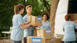 © Gorodenkoff - Happy Group of Volunteers Working on Delivering Humanitarian Aid and Donations, Loading Boxes into a Cargo Van. Successful Charity Workers High Five Each Other.