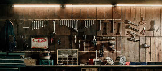 Workshop scene. Old tools hanging on wall in workshop, Tool shelf against a table and wall, vintage garage style