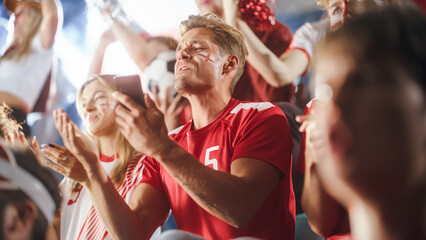  Sport Stadium Event: Handsome Caucasian Man Cheering. Crowd of Fans with Painted Faces Shout for their Red Soccer Team to Win. Scoring a Goal Celebration, Championship Victory. Low Angle Tribune Shot