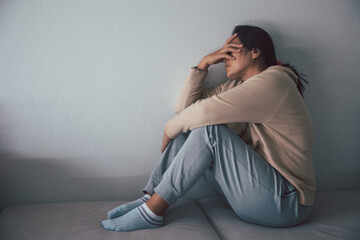 Wall Mural - Schizophrenia with lonely and sad in mental health depression concept. Depressed woman sitting against floor at home with dark room feeling miserable. Women are depressed, fearful and unhappy.