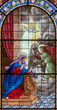 DOMODOSSOLA, ITALY - JULY 19, 2022: The Annunciation on the stained glass in church Chiesa dei Santi Gervasio e Protasio by Luigi Fontana from 19. cent.