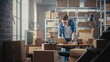 © Gorodenkoff - Inventory Manager Packaging a Stylish Bicycle Seat Sold to a Client Online. Preparing a Small Cardboard Parcel for Postage. Young Small Business Owner Working in Warehouse.