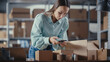 © Gorodenkoff - Inventory Manager Using Smartphone to Scan a Barcode on Parcel, Preparing a Small Cardboard Box for Postage. Young Female Small Business Owner Working on Laptop in Warehouse with Colleague.