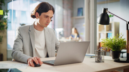 Fototapete - Stylish Male Employee in Gray Casual Jacket Working on Laptop in Office During Daytime. Close Up on Hands of a Manager Typing Texts on a Computer, Writing Emails and Using Mouse.