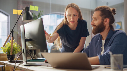 Wall Mural - Art Director and Graphic Designer Discussing a Marketing Campaign for Business Partner. Successful Female and Male Colleagues Collaborating on a Project. Small Creative Team Working in the Office.