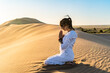 © ADDICTIVE STOCK - Woman gesticulating namaste in desert