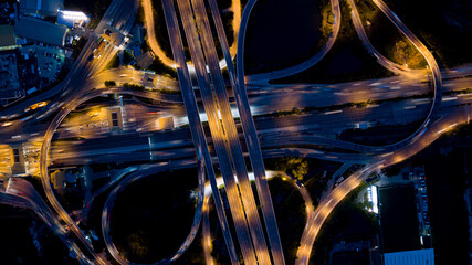 Wall Mural - Aerial drone photo of ring road multi level circular junction road, road junction.Aerial view of the transportation,traffic,route and expressway.Night city traffic on 4-way street intersection circle.