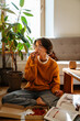 © Drobot Dean - Young white woman in eyeglasses eating coffee while sitting on floor