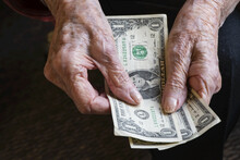 Senior Woman's Hands Counting Out A Few Dollars; Olympia, Washington, United States Of America