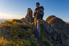 Hiker on the Pioneer Ridge-Austin Helmers Trail after sunrise; Alaska, United States of America