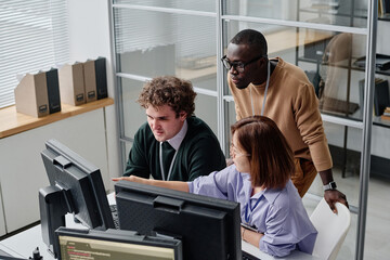 High angle view of team of programmers developing security program on computers during their work in office