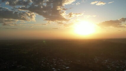 Wall Mural - Going down sun over clouds aerial drone view background