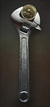 Adjustable Wrench Holding Canadian One Dollar Coin