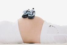 Baby Shoes On Pregnant Woman's Belly