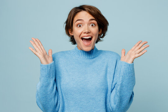 young surprised overjoyed fun winner caucasian woman wear knitted sweater look camera spread hands s
