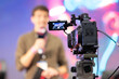 © KONSTANTIN SHISHKIN - A movie camera shoots a man on stage at the game expo