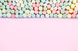 Kolorowe pianki marshmallow na różowym tle
