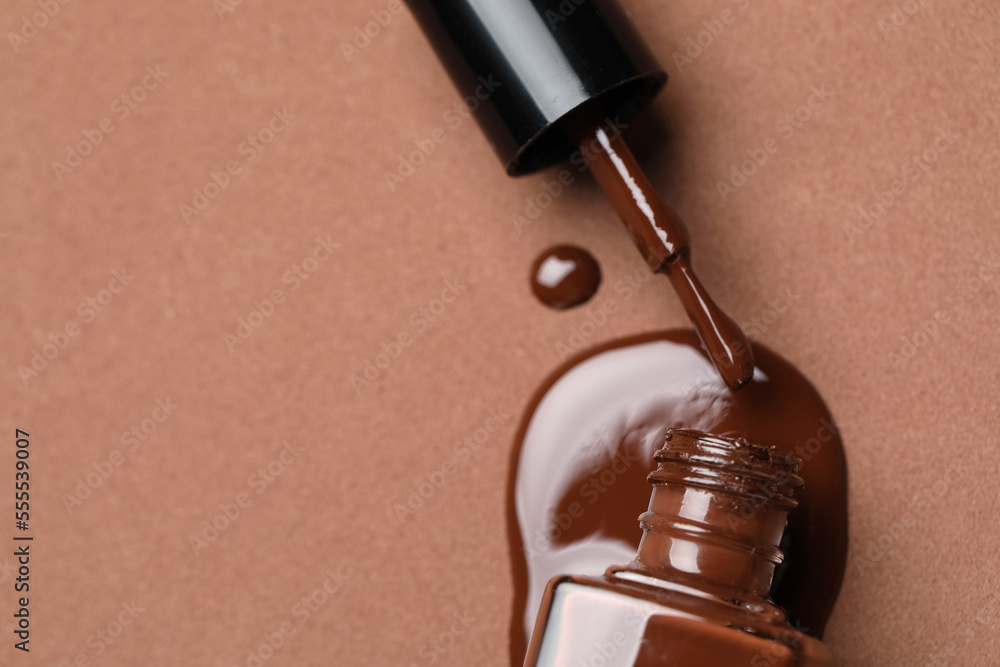 Spilled nail polish on brown background