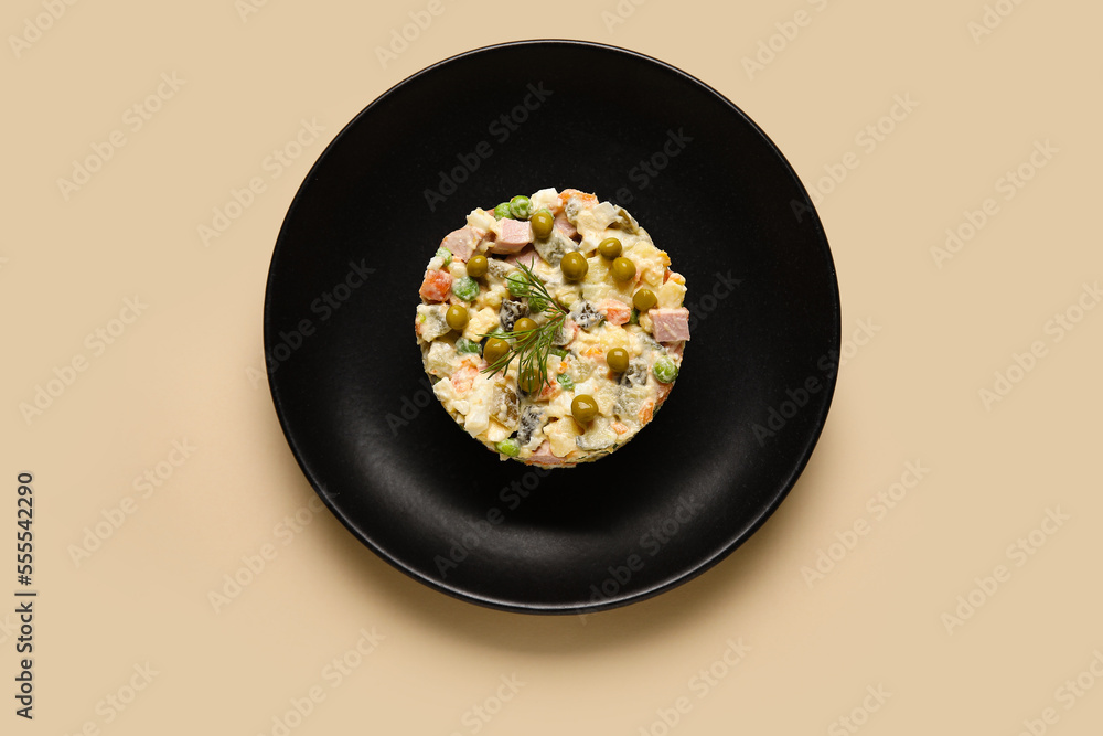 Plate with delicious Olivier salad on color background