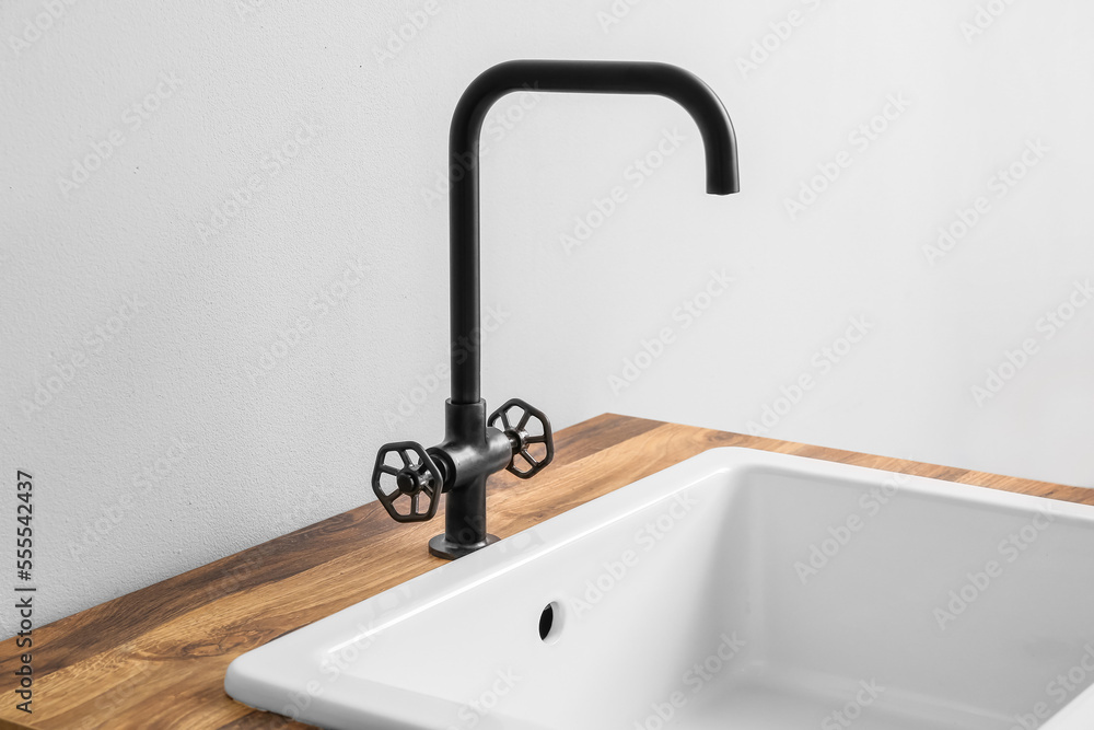 Table with ceramic sink near light wall, closeup