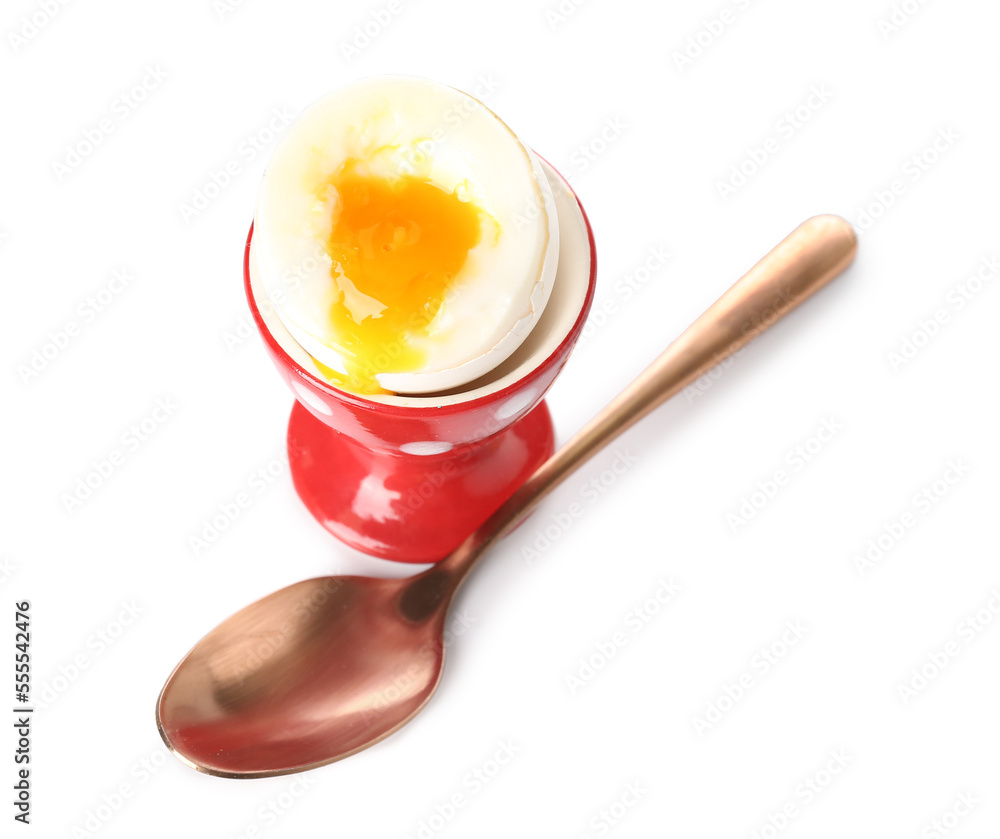 Cup with soft boiled egg and spoon on white background