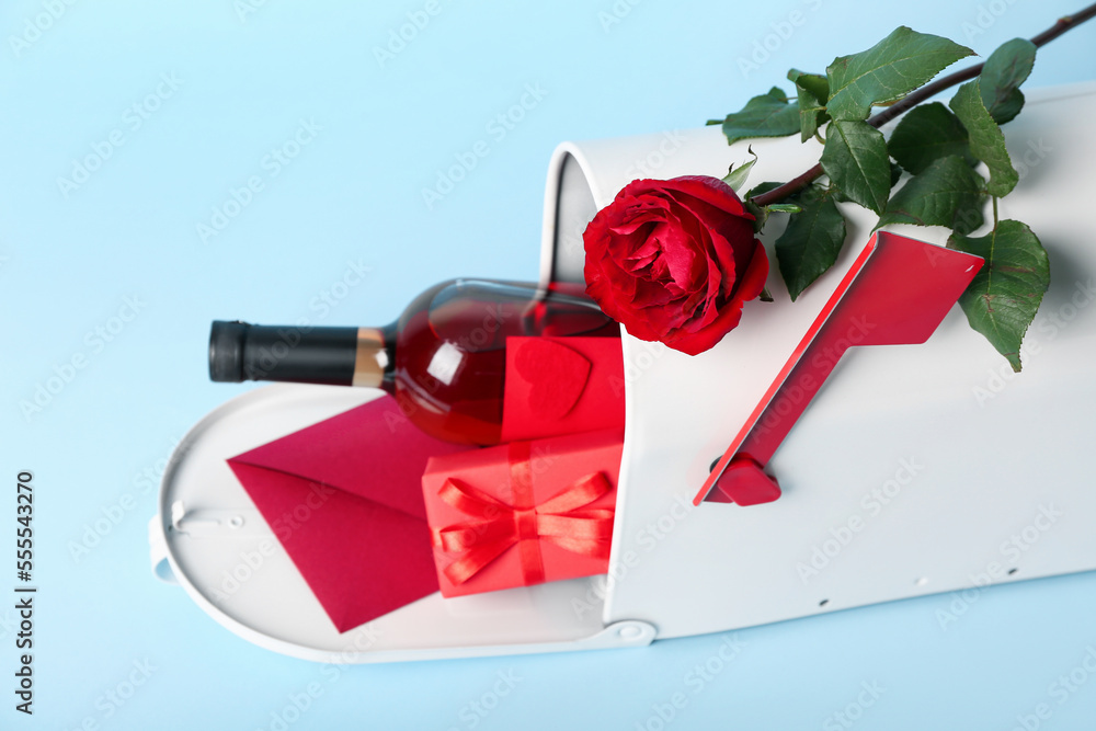Mailbox with letter, bottle of wine, rose and gift on blue background. Valentine's Day celebration