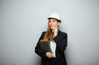 © Yuriy Shevtsov - Serious thinking business woman holding book. Female worker in white safety helmet.